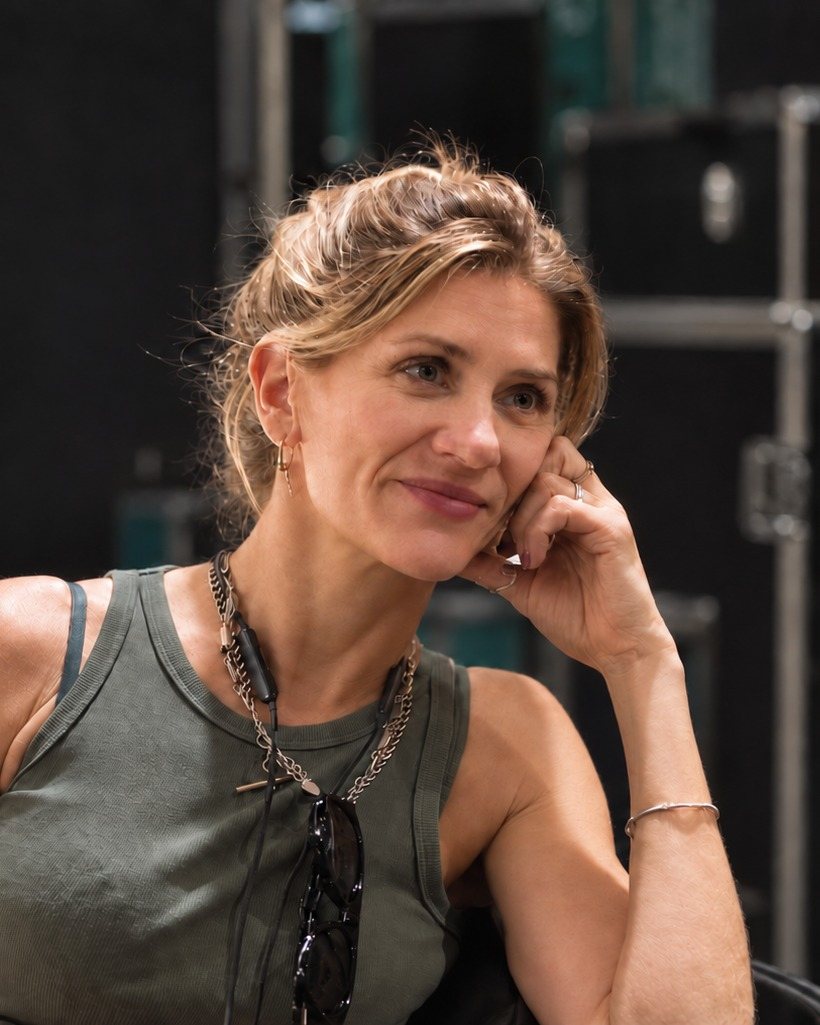 Ali Winton backstage, seated among flight cases