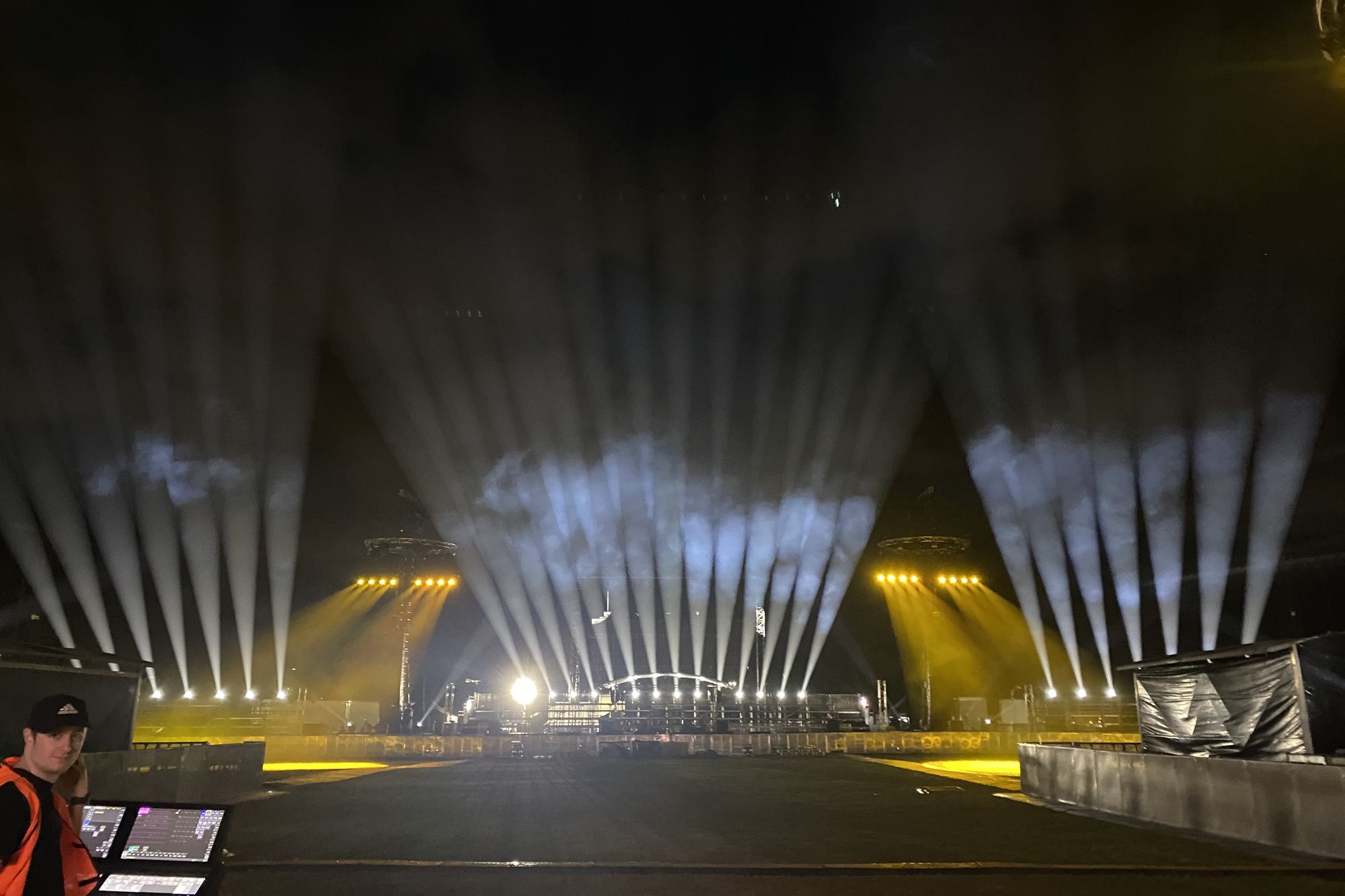 Stadium show at night, light beams over the stage