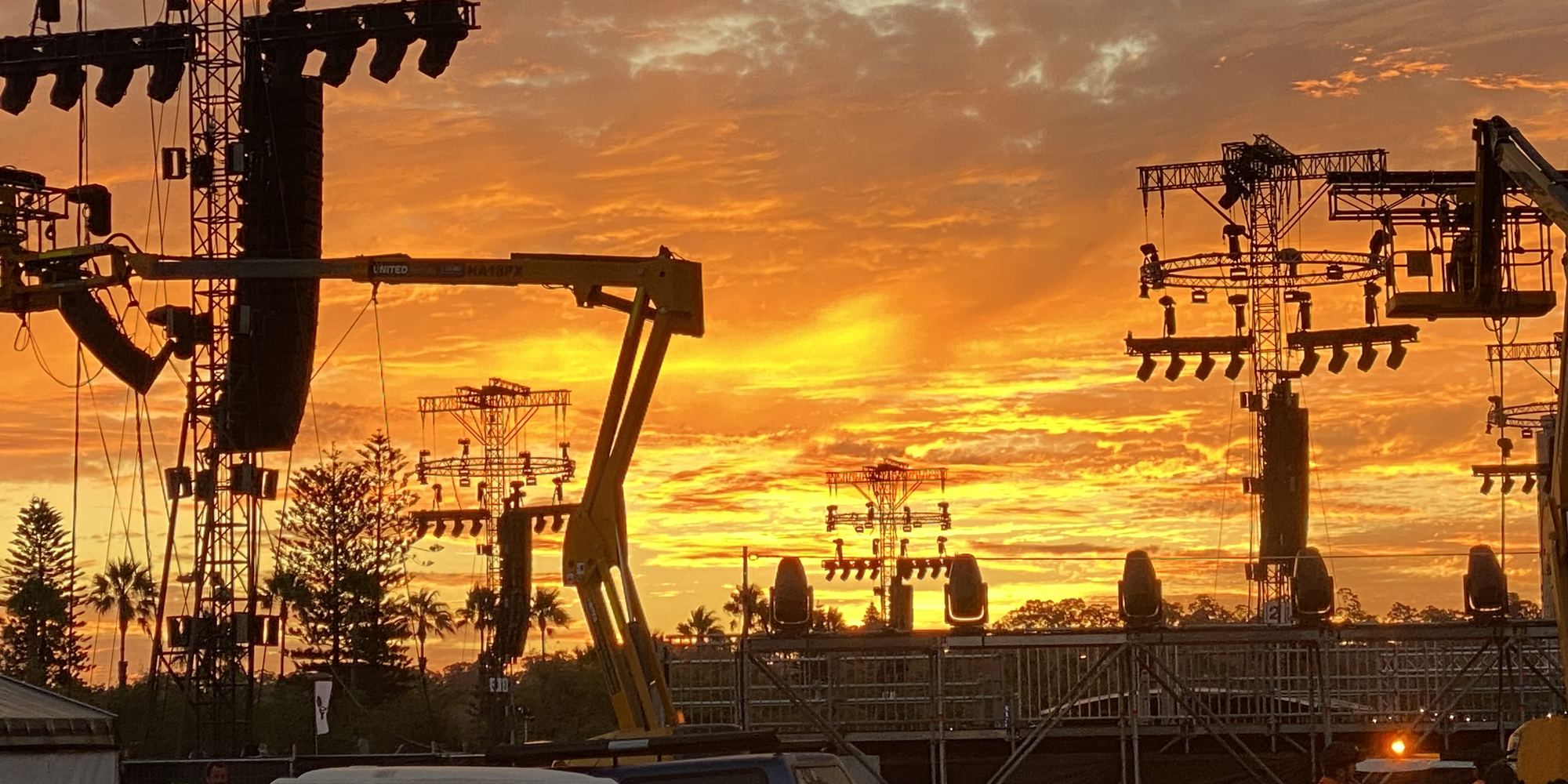 Stage build at sunset, trusses and crew